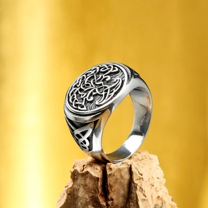 Detailed close-up of a vintage Celtic tree of life steel ring on a cork base
