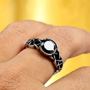 Macro shot of men's Celtic knot ring with a large faceted black gemstone inlay