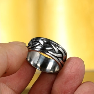 Macro detail of men's Viking woven steel ring with vintage oxidized relief pattern