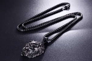 Détail d'un pendentif tête de lion en acier inoxydable pour homme avec une chaîne tressée grise