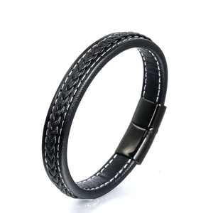 Detail of black braided leather bracelet featuring white stitching and magnetic clasp