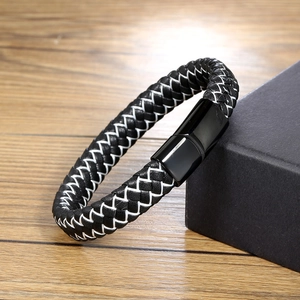 Détail macro du bracelet en cuir tressé noir et blanc avec fermoir en métal noir poli