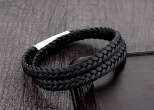 Close-up of double-layered black braided leather bracelet with a silver magnetic clasp