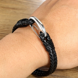 Close-up of men's hand-woven black leather bracelet with secure silver metal clasp
