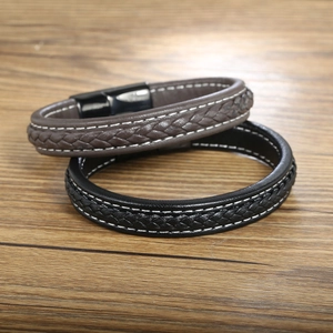Detail of woven black and brown leather bracelets with black magnetic metal clasps