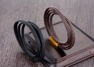 Détail de bracelets en cuir tressé multicouches avec fermoirs magnétiques en métal