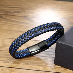 Vue détaillée du bracelet tressé en cuir avec surpiqûres bleues sur bois naturel