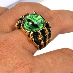 Macro shot of a punk dragon claw ring featuring a realistic green eyeball gemstone