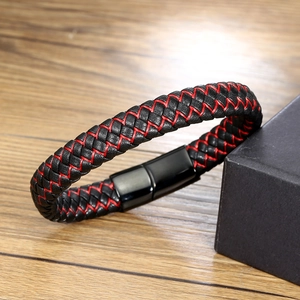Détail d'un bracelet en cuir tressé noir et rouge avec un fermoir magnétique noir poli