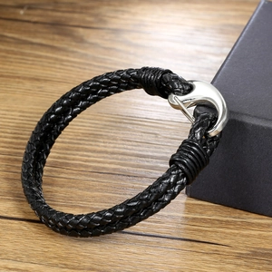Men's titanium steel woven leather bracelet with silver metal hook clasp on wood background