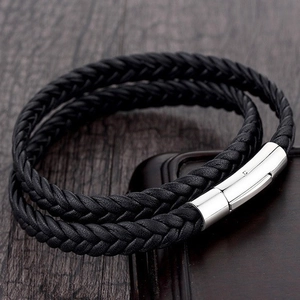 Double-layered braided leather bracelet with a silver magnetic clasp on wood background