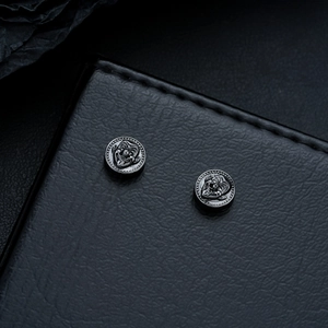 Vue macro de boucles d'oreilles magnétiques noires avec motif clown et bordure perlée