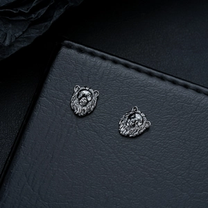 Détail macro des boucles d'oreilles magnétiques lion rétro en métal gris vintage sur cuir