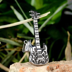 Colgante guitarra eléctrica plateada con relieve de llama sobre fondo piedra