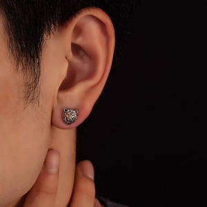 Gros plan détaillé d'une boucle d'oreille lion en argent vintage aux textures ciselées