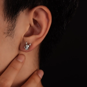 Macro view of vintage silver zodiac animal magnetic earring on earlobe with fur texture
