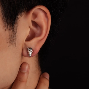 Detailed close-up of a realistic horse head earring with vintage engraved metal texture