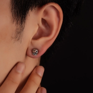 Clou d'oreille tête d'aigle vintage avec plumes détaillées sur l'oreille d'un homme
