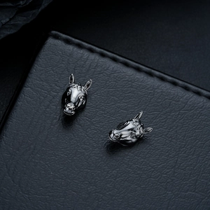 Detailed view of horse head earrings with black electroplated finish and fine engraving