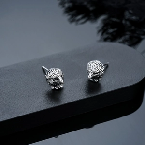 Gros plan détaillé des boucles d'oreilles tête d'aigle montrant la texture des plumes