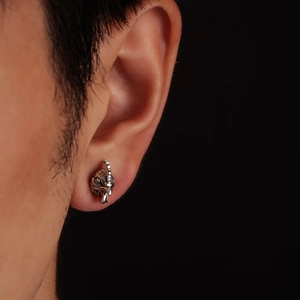 Close-up of rooster head stud earring with vintage silver finish on person's ear
