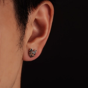 Detailed close-up of a vintage silver wolf head magnetic earring on male model