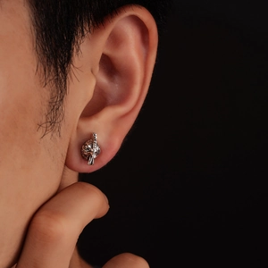 Detailed close-up of a silver zodiac rooster stud earring with vintage feather texture