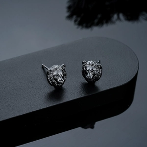 Vue détaillée des boucles d'oreilles tête de lion vintage avec finition noire mate texturée