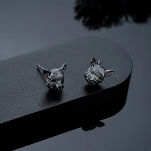Detailed close-up of dark gunmetal pig head studs featuring intricate carved textures