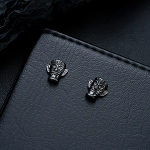 Macro shot of black Sanxingdui tribal mask studs on premium leather background