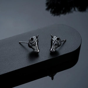 Macro detail of polished gunmetal zodiac horse head studs with intricate textures