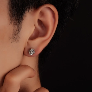 Detail of retro mask stud earring in antique silver finish worn on model ear