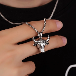 Vue détaillée d'un pendentif tête de bœuf vintage sur une chaîne en acier portée sur un t-shirt
