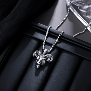 Macro shot of detailed silver ram head pendant on a black leather jewelry box