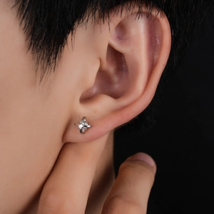Close-up of star cross stud earring in silver with sparkling center stone and micro-pave
