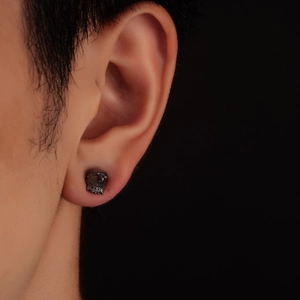 Vue latérale macro d'une boucle d'oreille tête d'aigle noire mate sur un mannequin