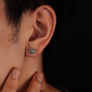 Detail view of silver magnetic stud earring with a 3D lion head relief on ear