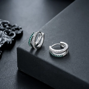 Close-up of silver hoop earrings with double row white and green zircon stones