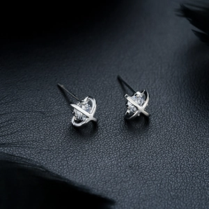 Macro shot of silver cross stud earrings with a sparkling central round zircon stone