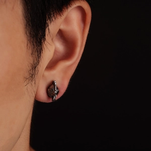 Retro rooster head ear stud in oxidized silver finish shown on a person's ear lobe