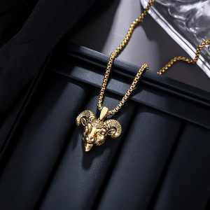 Macro view of detailed golden ram head pendant with textured horns on a box chain