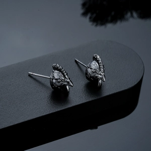 Detailed close-up of rooster stud earrings in black alloy with intricate 3D textures