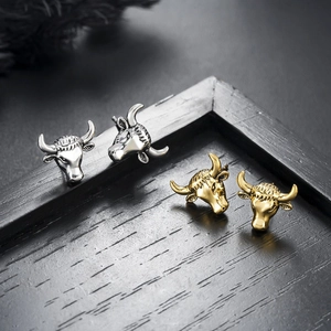 Ox head stud earrings in silver and gold metal finish featuring detailed carved animal design