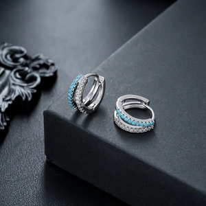 Macro shot of silver double-row earrings with blue turquoise beads and white zircons