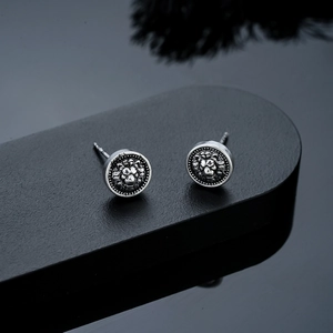 Macro view of vintage lion head earrings with detailed silver bead-edge relief craftsmanship