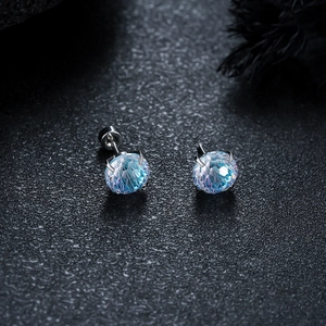 Macro shot of blue gradient gemstone stud earrings with four-claw stainless steel setting