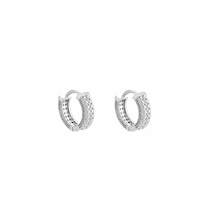 Paire de boucles d'oreilles huggie argentées avec cristaux micro-pavé sur fond blanc