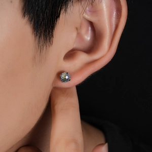 Close-up of a rainbow gradient zircon stud earring with a silver four-prong titanium base