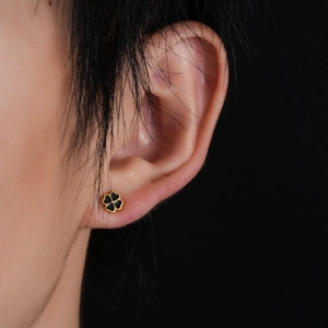 Titanium steel clover stud earring with black enamel and gold frame on model