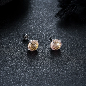 Macro view of champagne gradient round cut earrings with silver four-claw setting